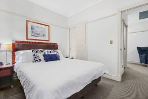 a bedroom with a large bed and a blue chair at Rendezvous Hotel-like City View 1b1b Apt in CBD in Brisbane