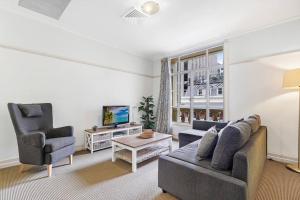 a living room with a couch and two chairs and a tv at Rendezvous Hotel-like City View 1b1b Apt in CBD in Brisbane
