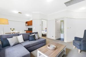 a living room with a couch and a table at Rendezvous Hotel-like City View 1b1b Apt in CBD in Brisbane