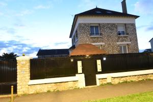 una casa con una valla y una puerta en Appartement de luxe avec sauna pour 4 Personnes, en Triel-sur-Seine