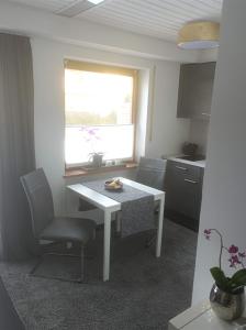 a kitchen with a table and a chair and a window at Relaxen vor den Toren Bambergs in Bischberg