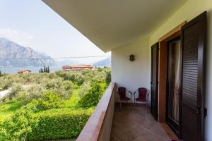 a balcony with two chairs and a view of the water at Hotel Alesi in Malcesine