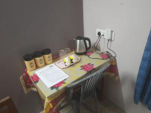 einen Tisch mit einem Wasserkocher und Tassen darauf in der Unterkunft 'O' Palmar Beach Cottages Benaulim in Benaulim + 12 Fotos