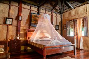 a bedroom with a bed with a net on it at Playa Encantada Beach Resort in El Nido +82 photos