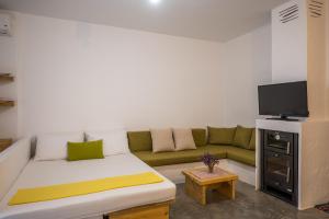 a living room with a couch and a flat screen tv at Γκαρσονιέρα #1 in Heraklio
