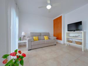 een woonkamer met een bank en een tv bij Vivalidays Angels - Blanes - Costa Brava in Blanes