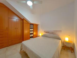 1 dormitorio con 1 cama blanca y 2 luces en Vivalidays Angels - Blanes - Costa Brava, en Blanes