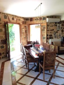 a dining room with a wooden table and chairs at Angelica Villas Hotel Apartments in Ancient Epidauros