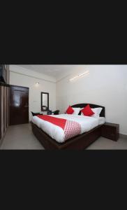 a bedroom with a large bed with red pillows at Hotel Best stay haridwar by Shiva Palace in Haridwār