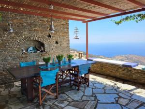 a table and chairs on a patio with a stone oven at The Stone Lookout Villa in Apróvaton