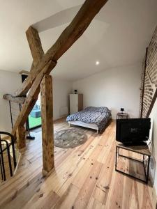 a bedroom with a bed and a wooden floor at Duplex belle pierre in Digoin