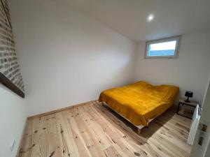 1 dormitorio con 1 cama con manta amarilla en Duplex belle pierre, en Digoin