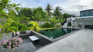 una piscina en medio de un jardín en KhaoTao Homestay เขาเต่าโฮมสเตย์, en Khao Tao