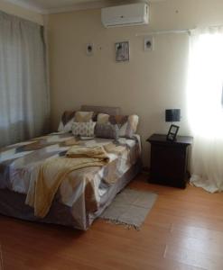 a bedroom with a bed and a table and a window at JustV14 in Mahikeng
