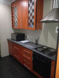 a kitchen with a stove and a microwave at JustV14 in Mahikeng