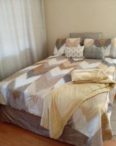 a bed with a comforter on it in a bedroom at JustV14 in Mahikeng