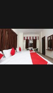 a bedroom with a large white bed with red pillows at Hotel Best stay haridwar by Shiva Palace in Haridwār