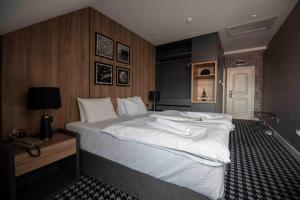 um quarto com uma cama grande e lençóis brancos em Hotel Platani em Trebinje