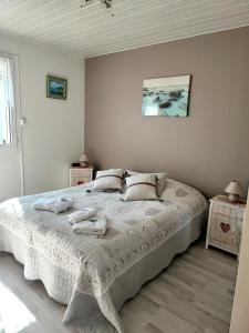 een slaapkamer met een groot bed en handdoeken bij L'ESCALE Côte d'Opale in Hesdigneul-lès-Boulogne