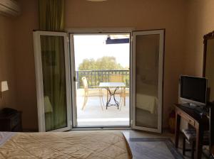 a bedroom with a sliding glass door leading to a patio at Angelica Villas Hotel Apartments in Ancient Epidauros