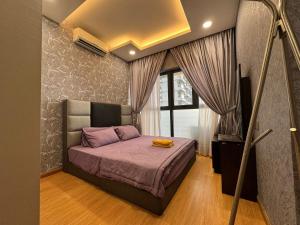 um quarto com uma cama com lençóis roxos e uma televisão em Dangabay 2bedroom Seaview Luxury Design Unit em Johor Bahru
