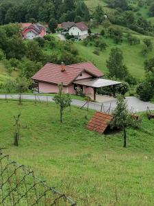 una casa con techo rojo en un campo en Hiška na gorci, en Podčetrtek