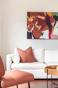 a living room with a couch and a painting on the wall at The Elements l Fire l 4 Stunning Apartments each with Private Outdoor Dining l Walk to the Beach l Family Friendly l Wifi l Netflix l Outdoor Shower l Communal BBQ Pavilion and Lawn Area l in Christies Beach