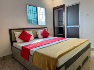 a bedroom with a large bed with red pillows at Hotel Nalanda City in Nalanda