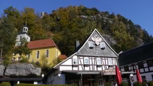 ein Gebäude vor einem Berg mit einer Kirche in der Unterkunft Weißer Stein Jonsdorf in Kurort Jonsdorf