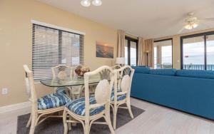 a living room with a table and a blue couch at Phoenix X 317 in Orange Beach