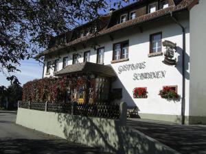 ein weißes Gebäude mit Blumen auf der Seite in der Unterkunft Gasthaus zum Schwanen in Ühlingen-Birkendorf