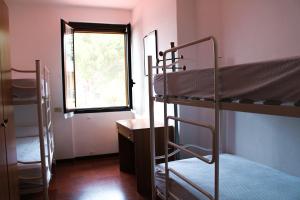 マネルバ・デル・ガルダにあるCamping La Roccaの二段ベッド2台と窓が備わる客室です。