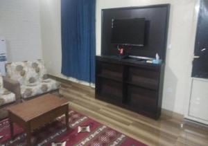 a living room with a flat screen tv and a couch at نجمة الحسناء in Jeddah