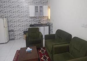 a living room with two green chairs and a table at نجمة الحسناء in Jeddah