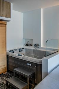 a large bath tub in a room with a table at Agia Sofia luxury suite & spa in Thessaloniki