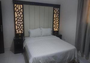 نجمة الحسناء في جدة: غرفة نوم بسرير ابيض ونوافذ