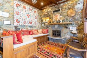 a living room with a couch and a stone wall at Nikbin Yamaç Pansiyon in Selcuk