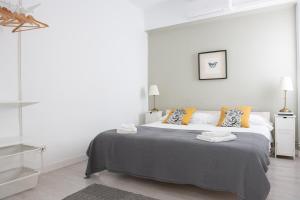 a white bedroom with a large bed with two pillows at Seneca7 near paseo de gracia in Barcelona