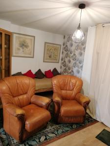 ein Wohnzimmer mit 2 Stühlen und einem Bett in der Unterkunft Le halage 65 m2 in Baudre