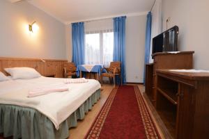 ビャウカにあるDom Wypoczynkowy Podhalankaのベッドとテレビが備わるホテルルームです。