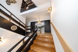 uma escadaria numa casa com pisos de madeira e grades pretas em Pensjonat Janosik em Zakopane