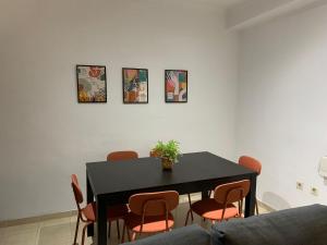 a dining room table with chairs and a black table at Apartamento cinta 3 habitaciones in Seville