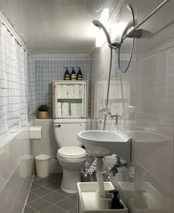 La salle de bains blanche est pourvue de toilettes et d'un lavabo. dans l'établissement J-Stay near Hongdae, à Séoul