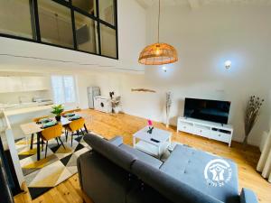 a living room with a couch and a table at Loft cocon climatisé - Imprenable vue sur le château Comtal in Carcassonne