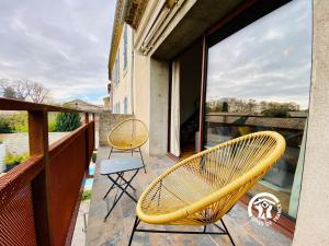 a balcony with two chairs and a large window at Loft cocon climatisé - Imprenable vue sur le château Comtal in Carcassonne
