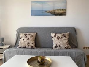 sala de estar con sofá gris y 2 almohadas en El Mirador de Llançà en Llança