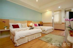 Una habitación de hotel con dos camas y un televisor. en Hualien Hai Bin Homestay, en Hualien City