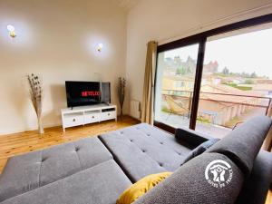 a living room with a couch and a large window at Loft cocon climatisé - Imprenable vue sur le château Comtal in Carcassonne