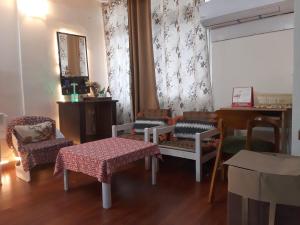 uma sala de estar com cadeiras, uma mesa e um espelho em Awasthi Kozi Stays B&B - closest to VFS em Nova Deli