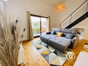 a living room with a couch and a large window at Loft cocon climatisé - Imprenable vue sur le château Comtal in Carcassonne